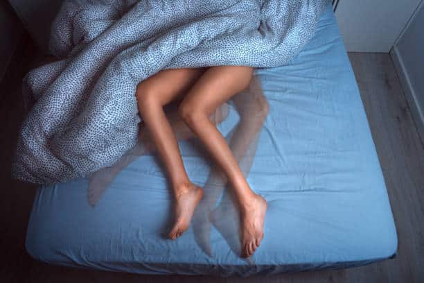 in bed with restless leg symptoms (RLS)