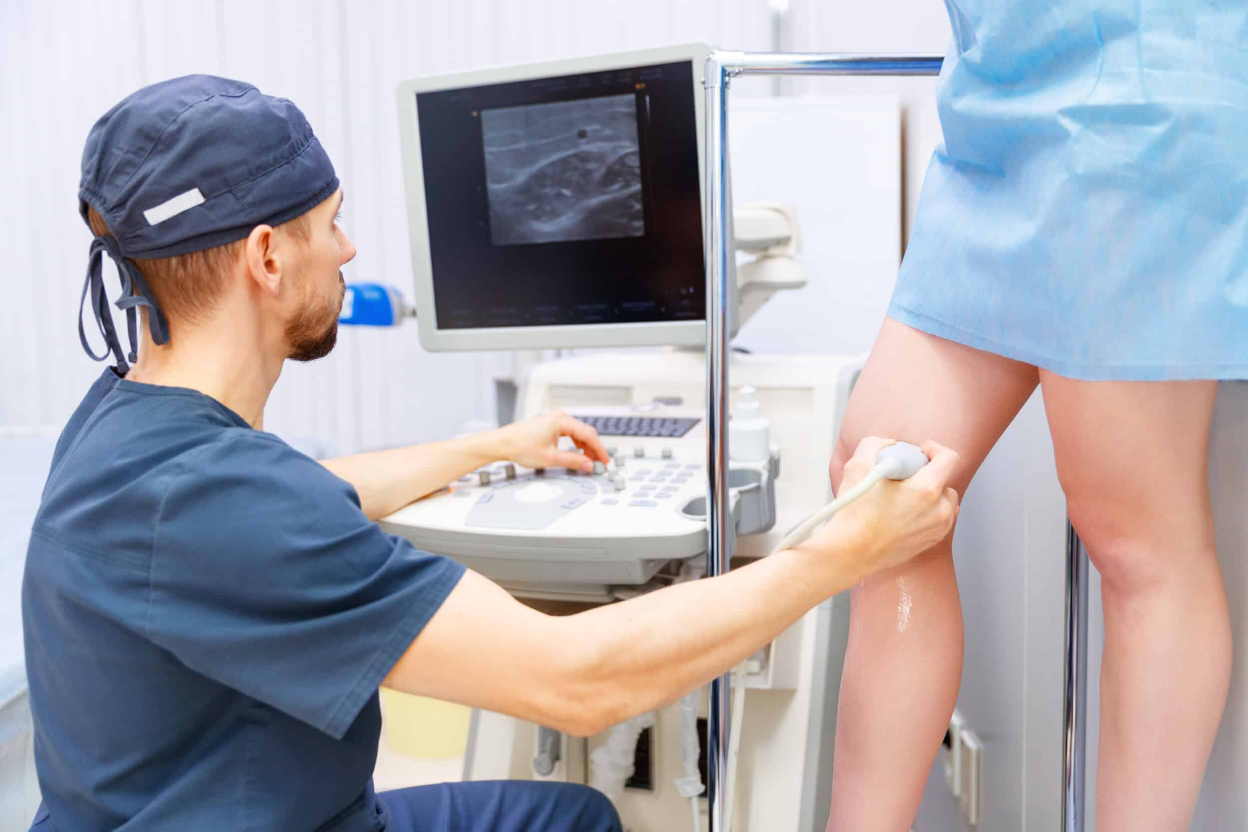 Medical professionals evaluate a chronic leg wound using ultrasound technology before a wound healing procedure