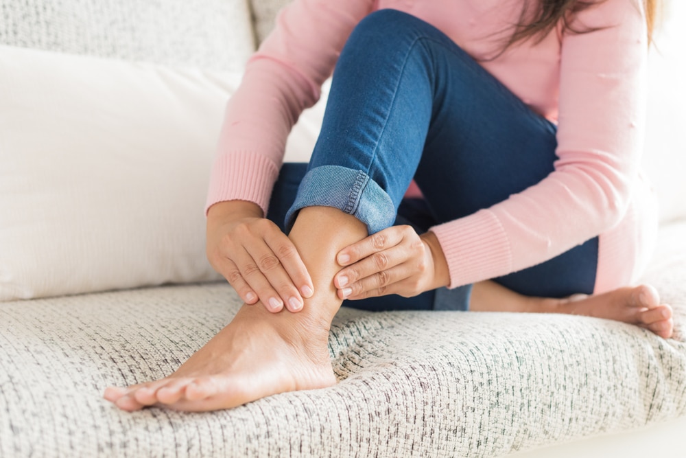 Woman rubbing her foot due to restless leg symptoms